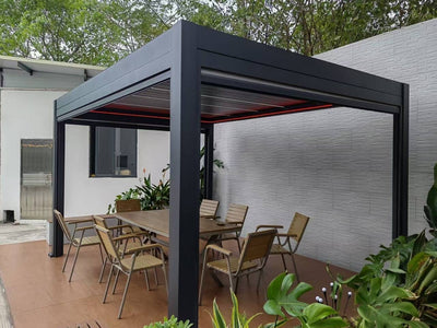 Pérgola bioclimática eléctrica de aluminio gris con mesa y sillas